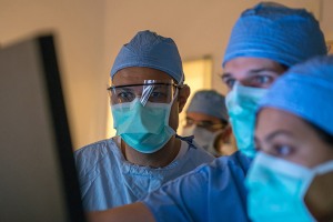 doctors in scrubs looking at a screen